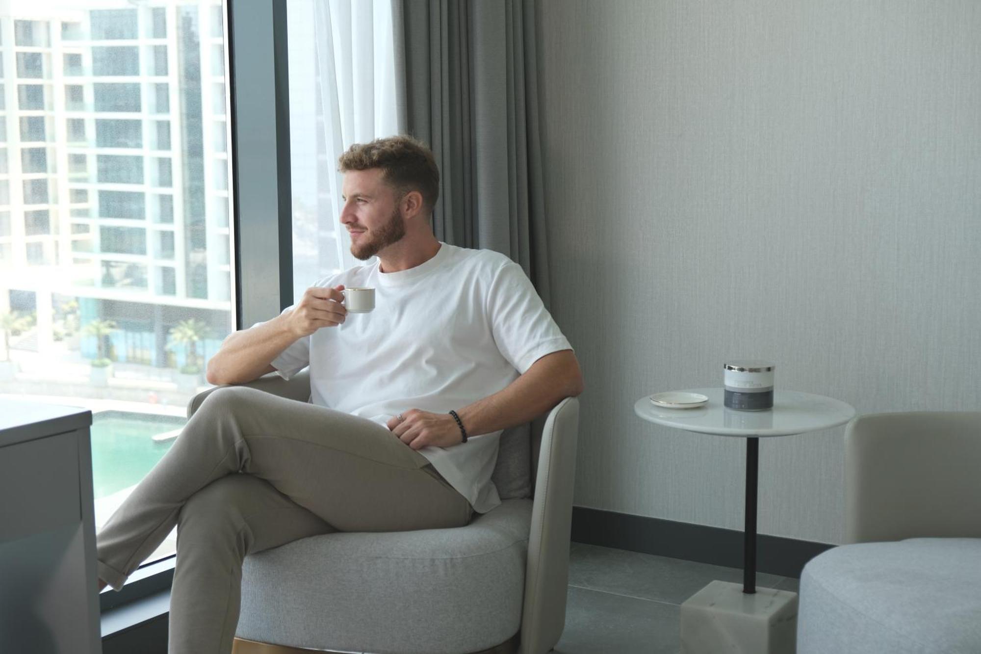 Отель Charthouse Bahrain Манама Экстерьер фото A man drinking coffee